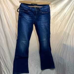 Bootcut Lucky Jeans with purple stitching on back pockets.